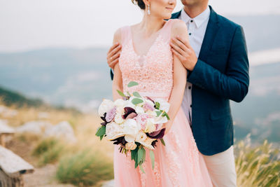 Midsection of couple embracing outdoors