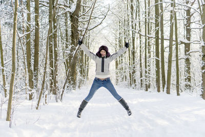 Woman standing on snow covered forest