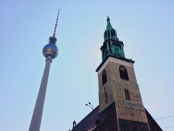 Low angle view of historic church with fernsehturm in background