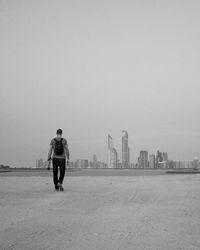 Full length of man standing on city against clear sky