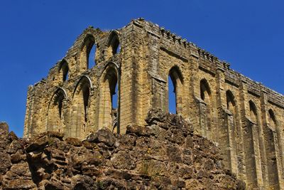 Low angle view of historical building against clear blue sky