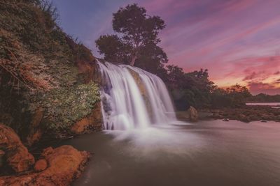 Scenic view of toroan waterfall against sky during sunset