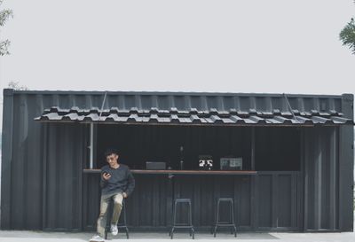 Full length portrait of man standing against building