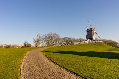 Traditional windmill on field against clear sky