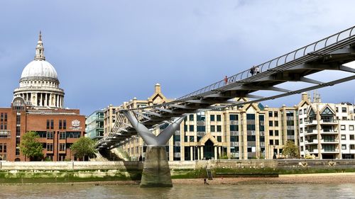 Bridge over river against buildings in city