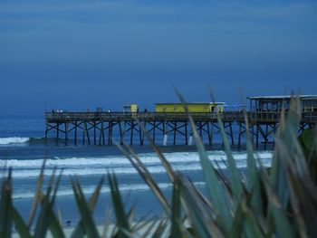 Pier over sea against blue sky