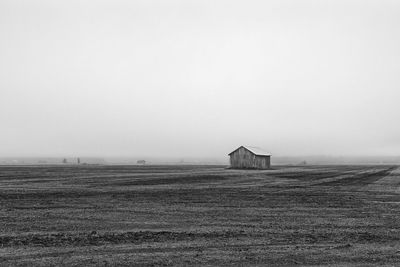 Barn on field against clear sky