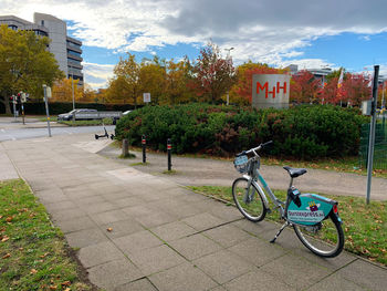 Bicycle parked on street against buildings in city