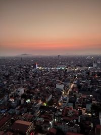 High angle view of illuminated city against sky during sunset