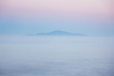 Scenic view of mountains against sky during foggy weather