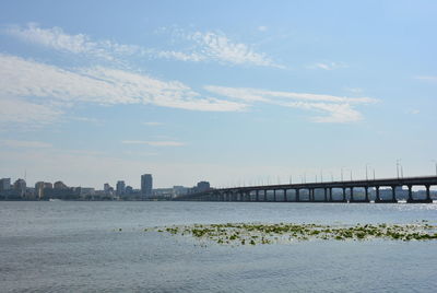 Bridge over sea against buildings in city