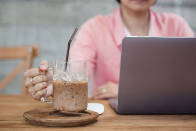 Midsection of man using mobile phone on table