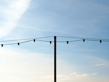 Low angle view of light bulbs against sky