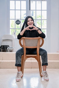 Portrait of young woman sitting on sofa at home