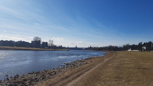 Scenic view of river against sky in city