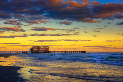 Scenic view of sea against dramatic sky during sunset