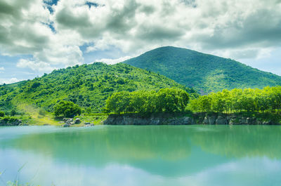 Scenic view of lake by trees against sky