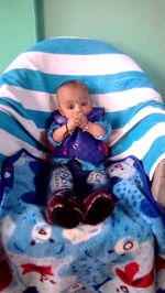 Portrait of cute baby girl lying on bed