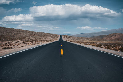 Empty road against cloudy sky