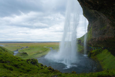 Scenic view of waterfall against sky