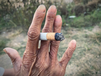 Close-up of hand holding cigarette