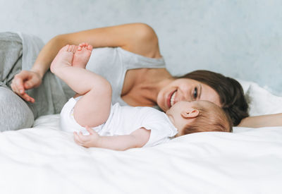 Rear view of woman lying on bed at home