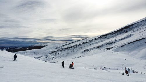 Tourists on snow covered mountain