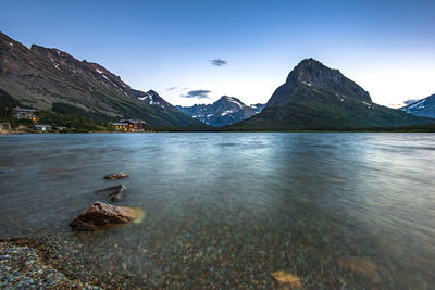 Scenic view of lake by mountain against sky