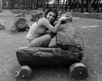 Portrait of smiling women sitting in wooden cart at park