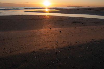 Scenic view of beach against sky during sunset