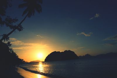 Scenic view of beach against sky at sunset