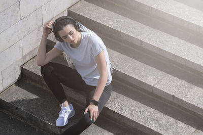 High angle view of young man sitting on staircase