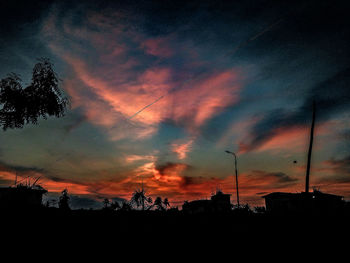 Silhouette of landscape against cloudy sky at dusk