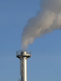 Smoke spews out of a chimney at an industrial plant