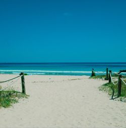 Scenic view of beach against clear blue sky