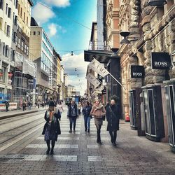 People walking on street amidst buildings in city