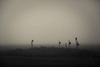 Silhouette field against clear sky at sunset