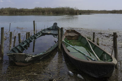 Abandoned boat moored in lake against sky