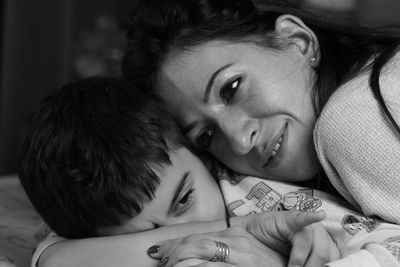 Close-up of mother with son lying on bed