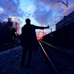 Railroad tracks against cloudy sky