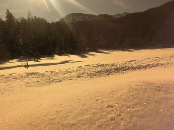 Scenic view of snow covered land against sky during sunset