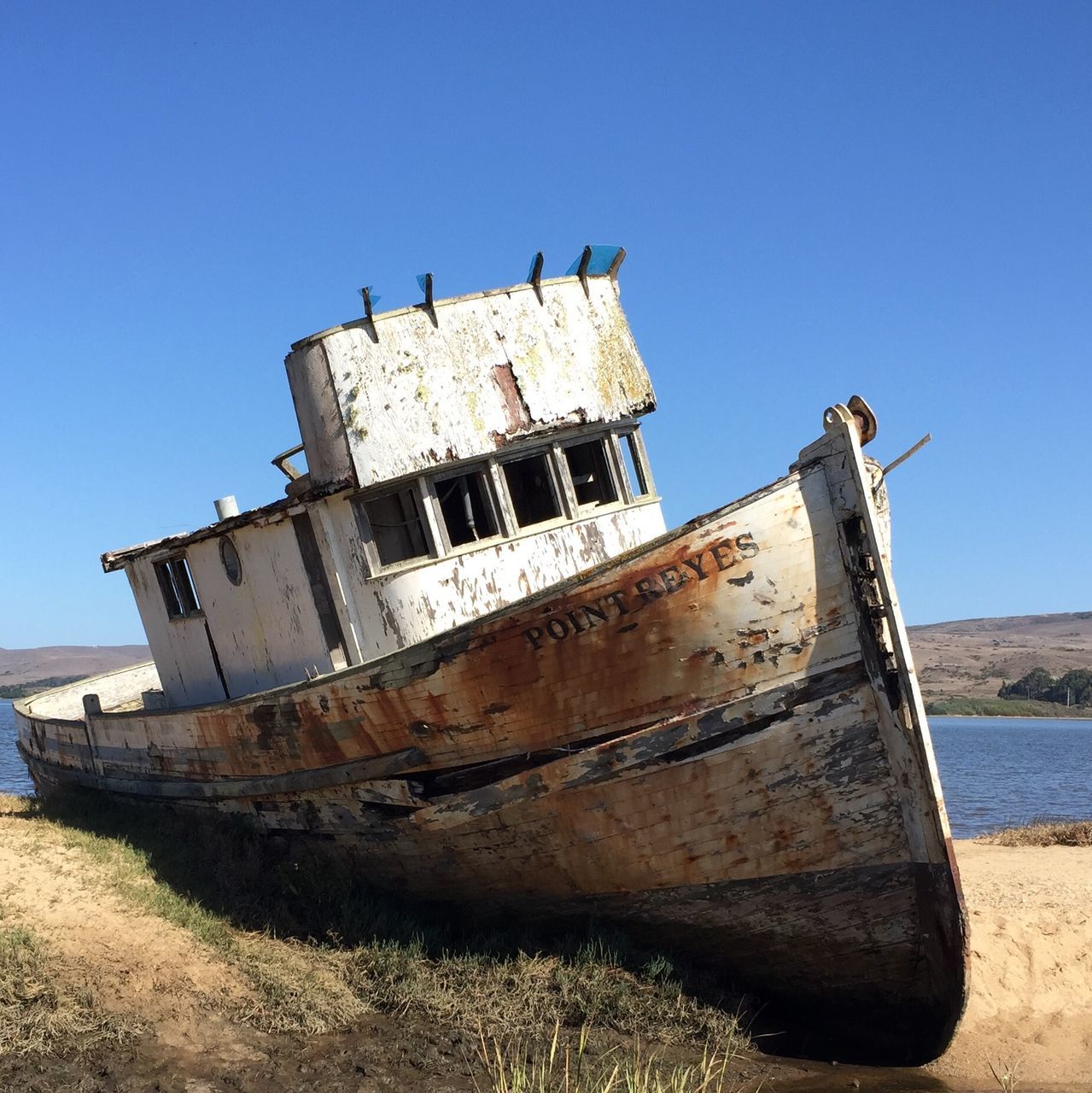 clear sky, blue, abandoned, damaged, built structure, obsolete, old, water, nautical vessel, run-down, architecture, deterioration, transportation, sea, copy space, mode of transport, building exterior, day, beach, sunlight