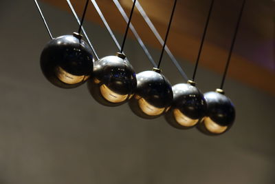 Close-up of pendulums hanging against wall