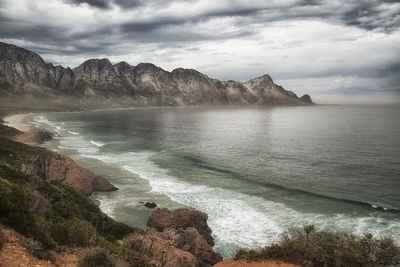 Scenic view of sea and mountains against sky