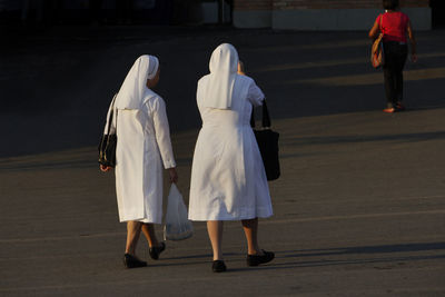 Rear view of nuns walking on street