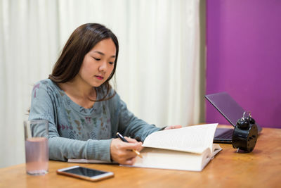 Portrait of young businesswoman working at table