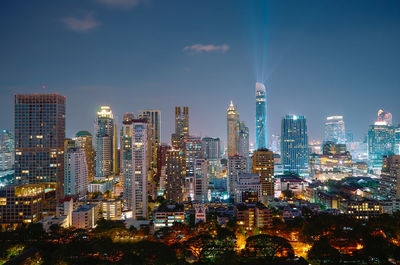 Modern buildings in city against sky during dusk