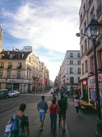 Buildings in city against cloudy sky