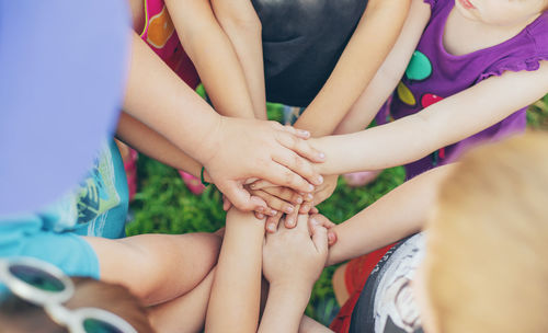 High angle view of kids with stacked hands