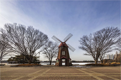 The windmill sculpture between the trees is beautiful.